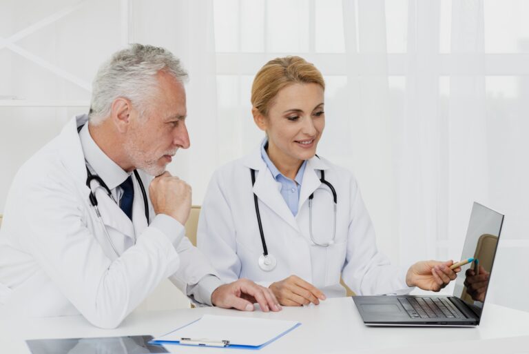doctors-looking-laptop-while-sitting-min
